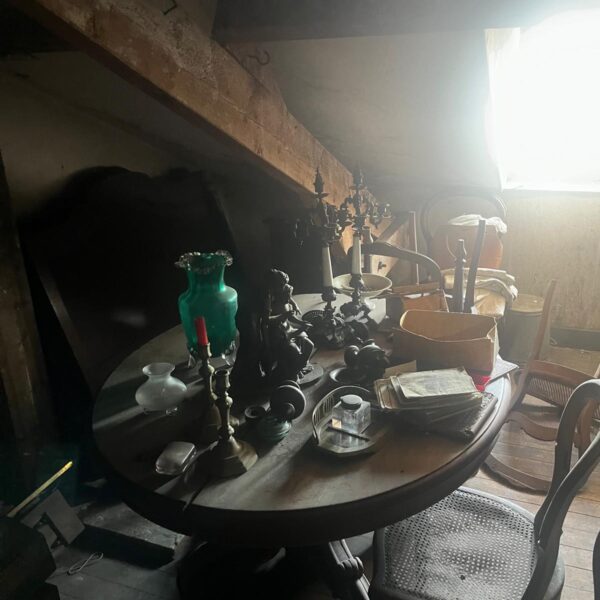 Guéridon ancien en acajou couvert de candélabres, d’un vase en verre vert et d’un encrier, avant estimation